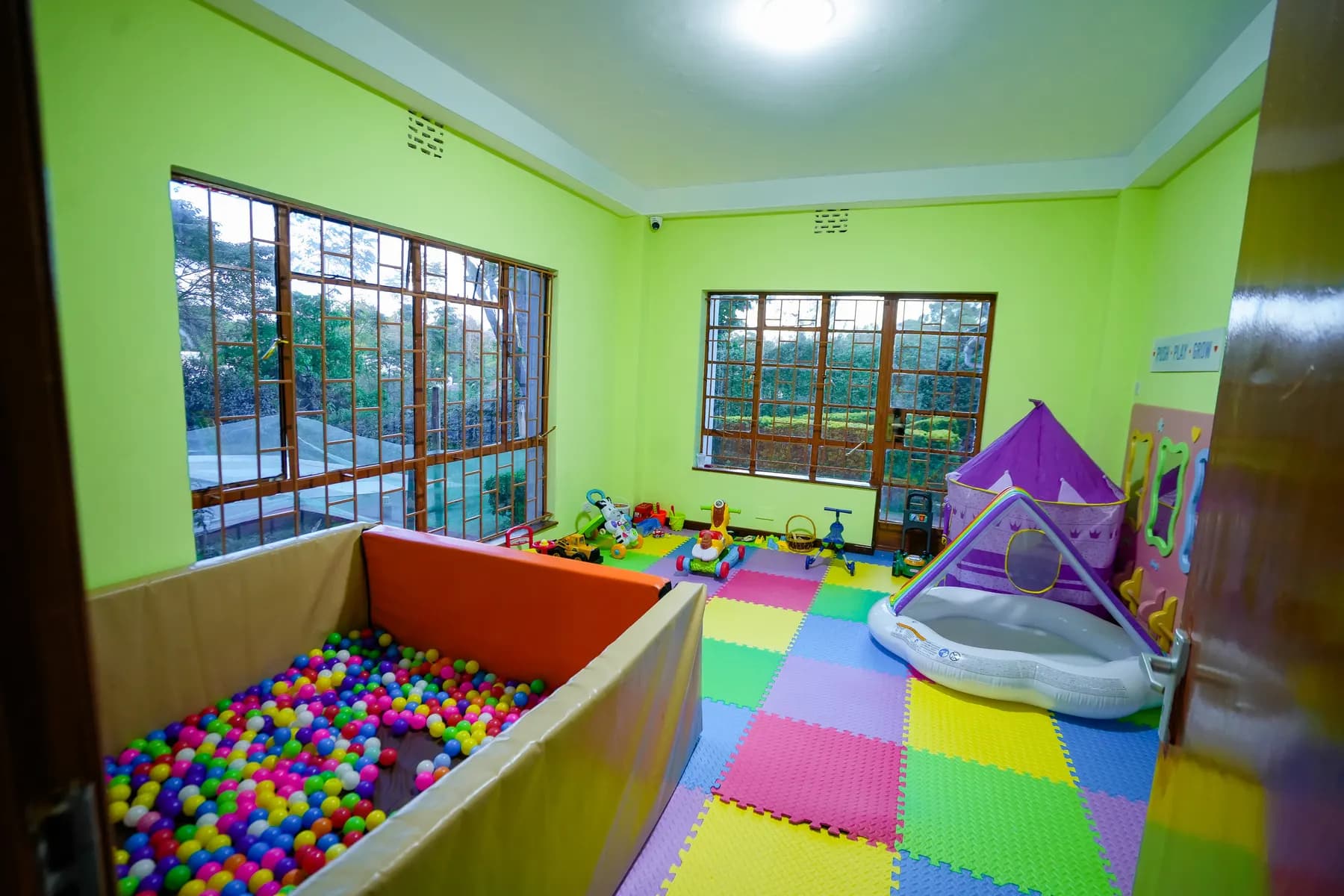 Ball pit and soft play corner under big bright windows