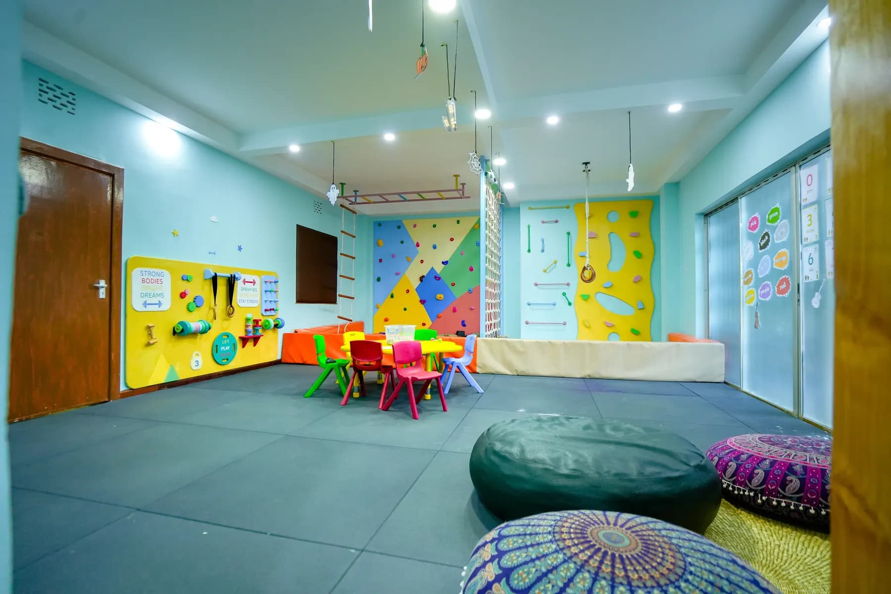 The climbing room, with a bouldering wall, rope ladders and a low activity table